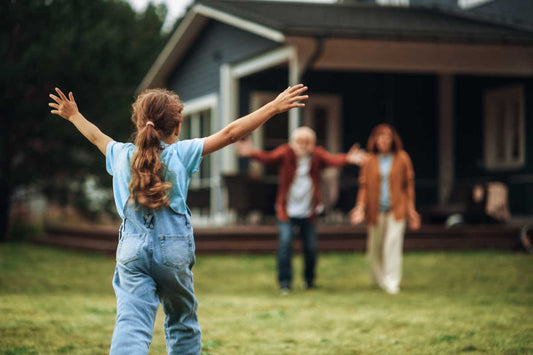 A child, her arms aloft, running to meet her grandparents