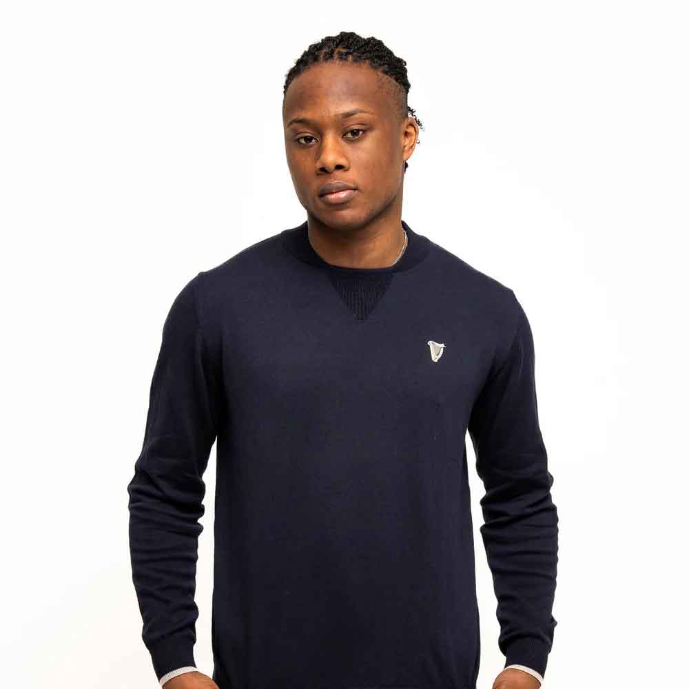 man wearing a guinness® navy performance cotton sweater on a white background