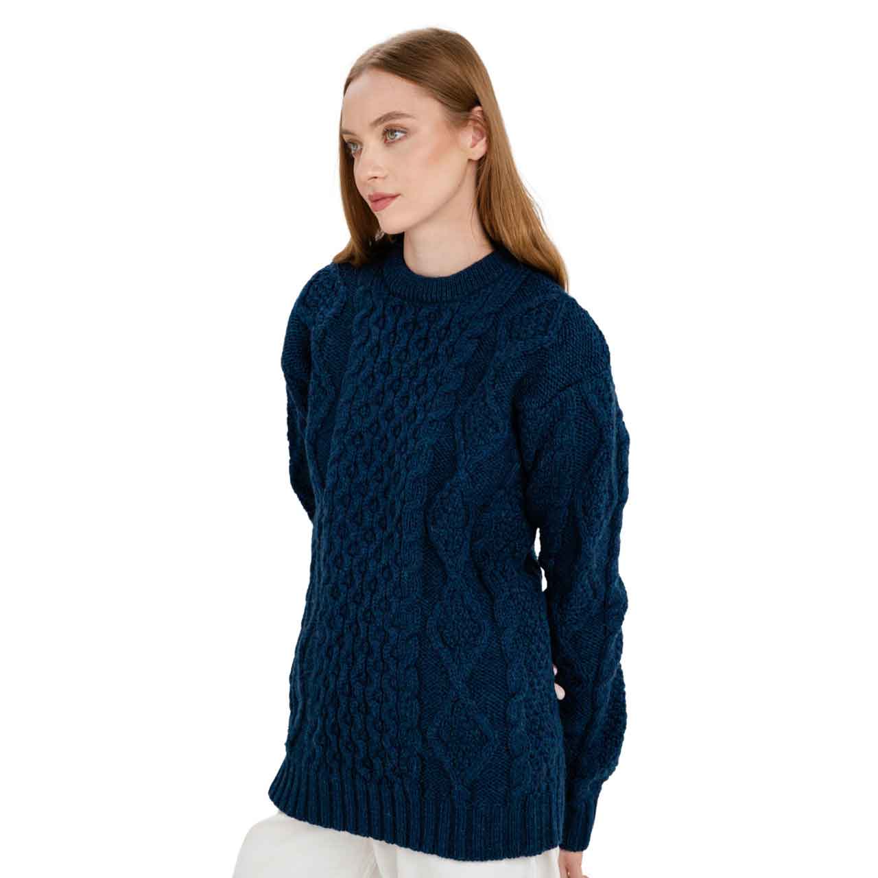 woman wearing a navy colored fisherman cable knit ladies sweater on a white background