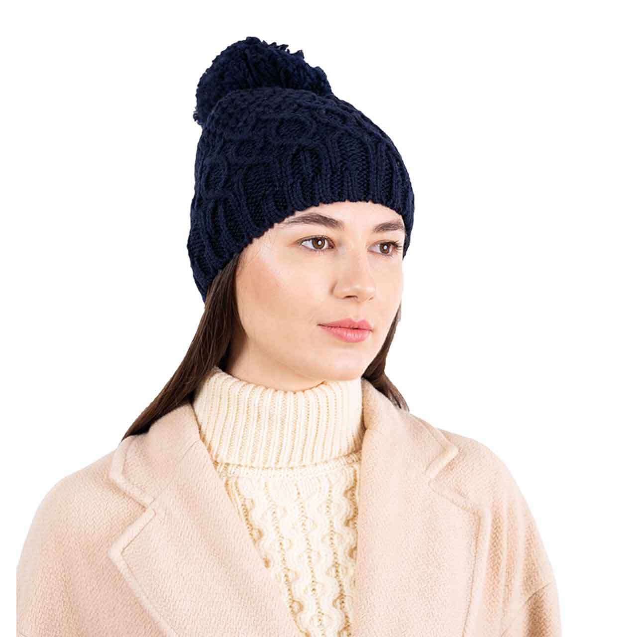 woman wearing a navy aran knit merino wool lined ladies beanie in front of a white background