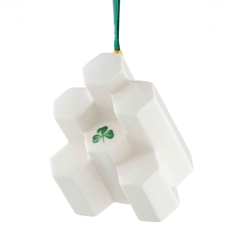 Giants Causeway Belleek Annual Ornament 2025 - A decorative ornament in style of hexagonal basalt columns with green shamrock at its center hanging from a green ribbon