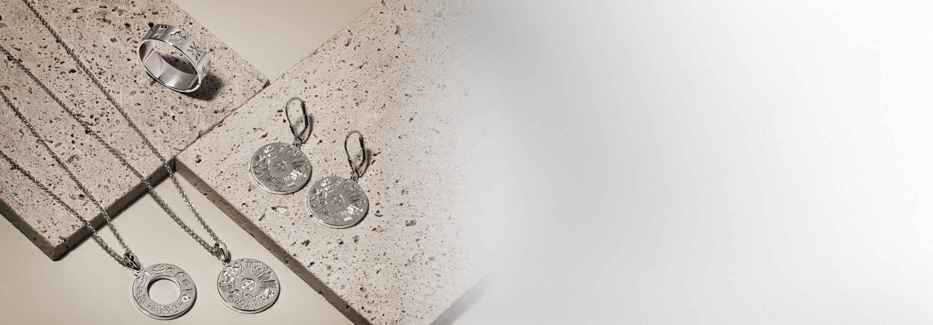 Silver History of Ireland rings, necklaces and earrings on a textured surface