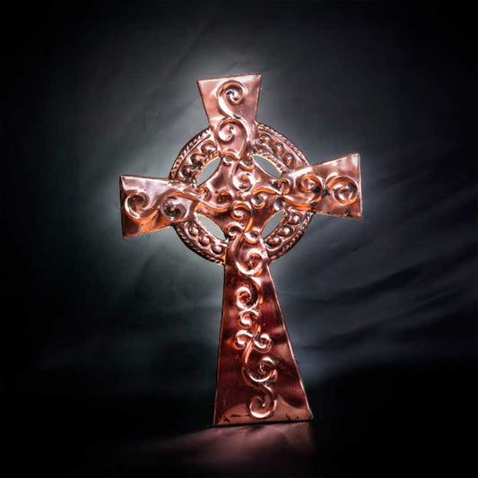 Copper Celtic Cross plaque with embossed Celtic spiral details in front of a black backdrop