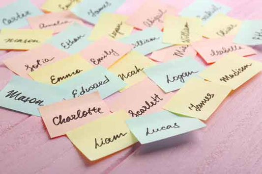 Paper stickers with different names on wooden background