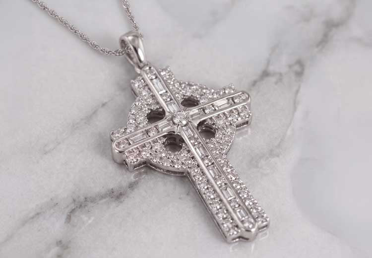 Irish Necklace 14k White Gold Diamond Celtic Cross Pendant, resting on a gray and white marble surface