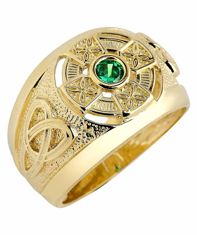 A gold ring with Trinity Knot designs and a central green gemstone.