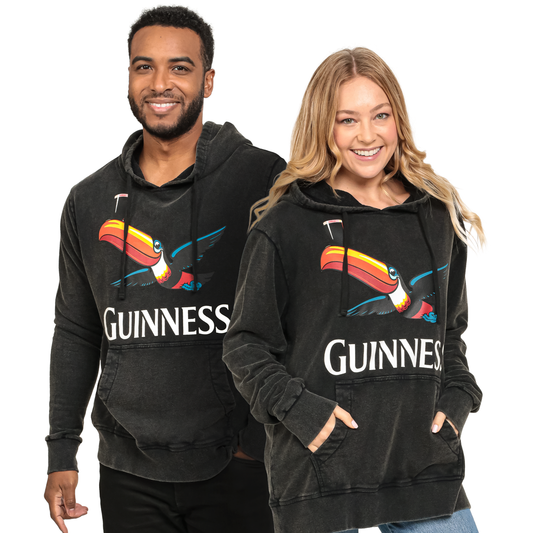 Two people wearing black Guinness hoodies with a toucan design on a white background