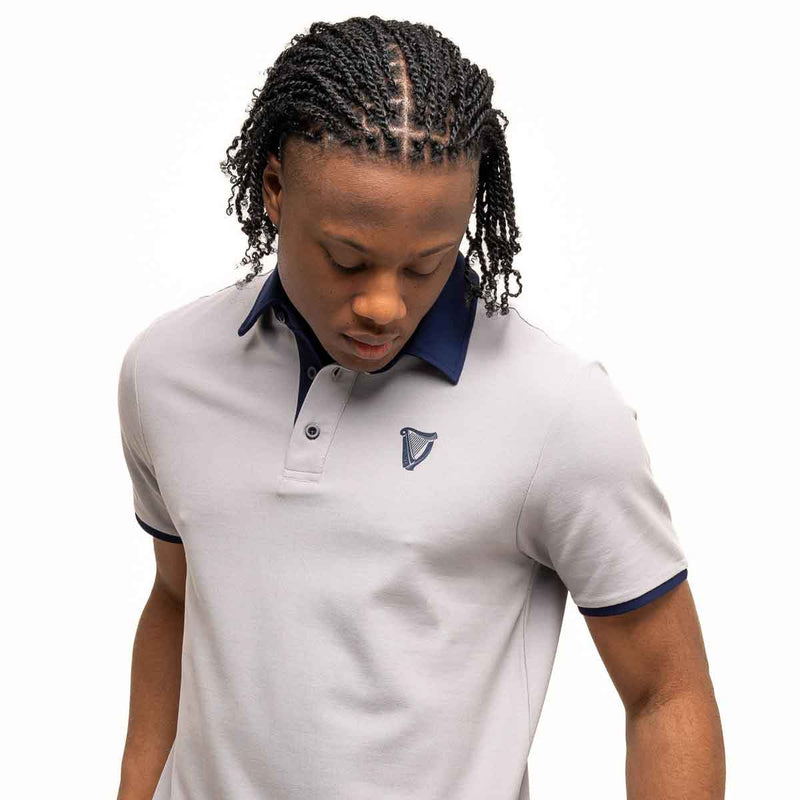 Person wearing a Guinness® Gray Performance Polo Shirt on a white background