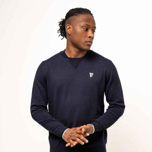 Man wearing a Guinness® Navy Performance Cotton Sweater on a white background