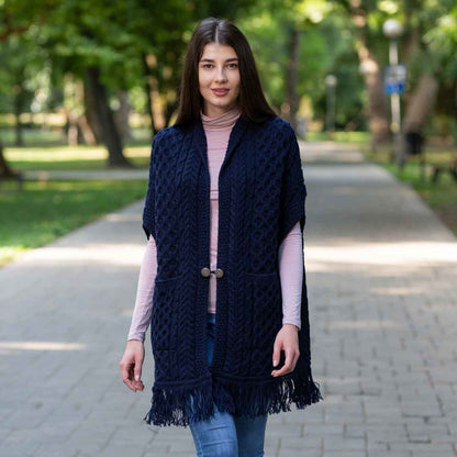 Woman wearing a navy Aran Knit Ladies Pocket Shawl in a park setting