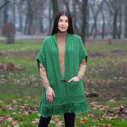 Woman wearing a green Aran Knit Ladies Pocket Shawl in a park setting