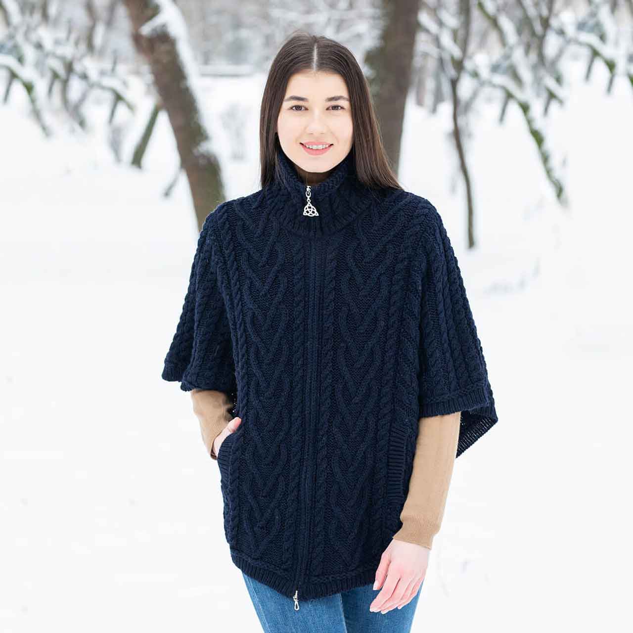 woman wearing a navy aran knit funnel neck poncho jacket in a snowy landscape