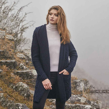 Woman wearing a navy Aran Knit Hooded Ladies Long Cardigan in a foggy, mountainous landscape