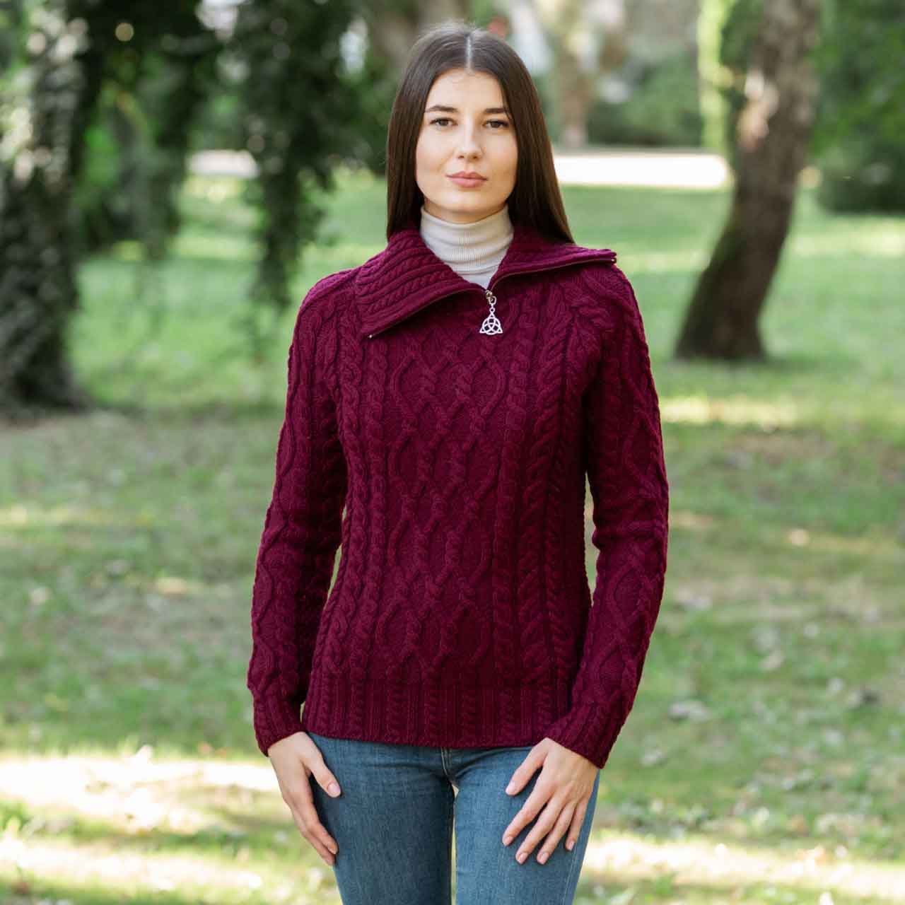 woman wearing a wine irish aran ladies merino wool zipper neck sweater in a park setting