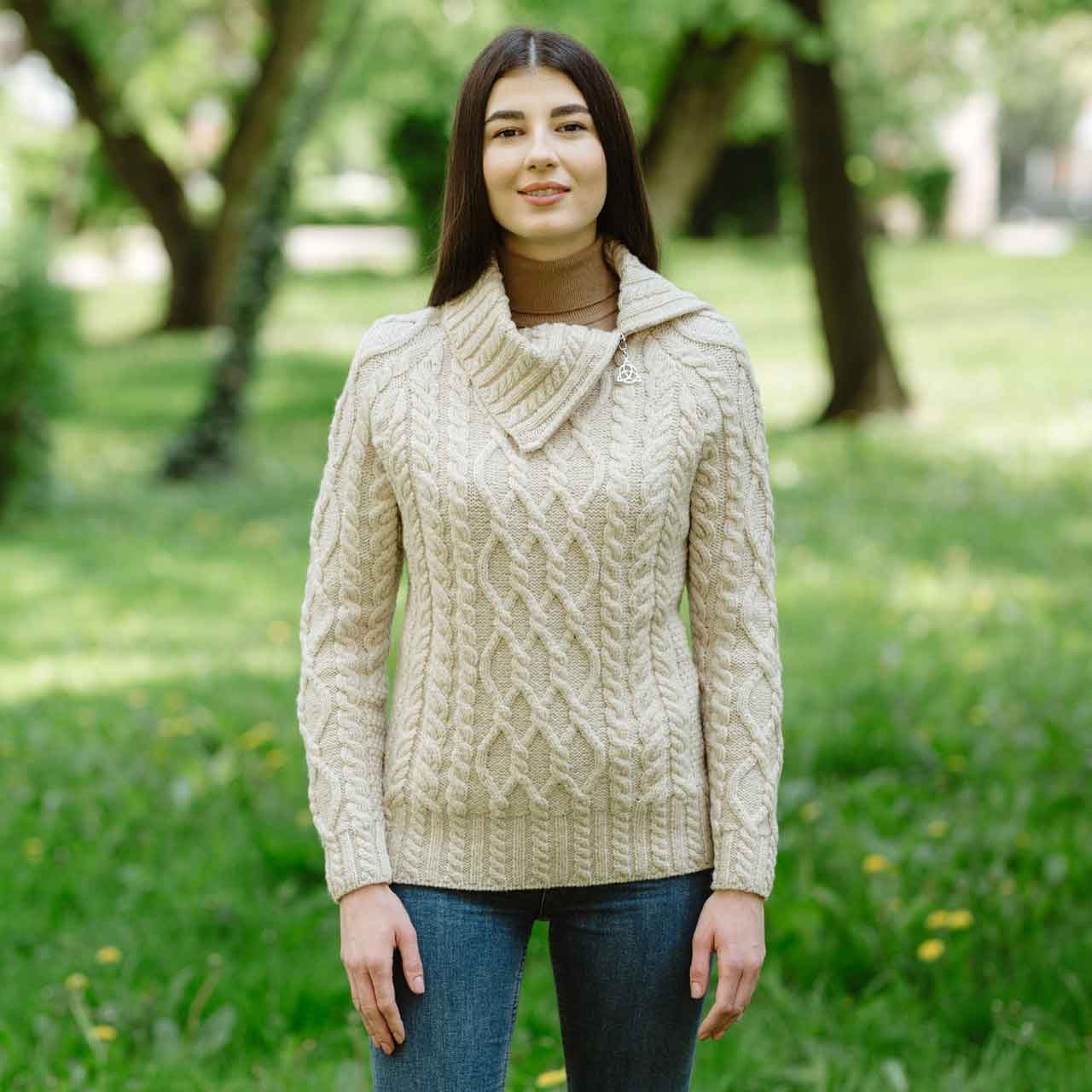 woman wearing a parsnip-colored irish aran ladies merino wool zipper neck sweater in a park setting