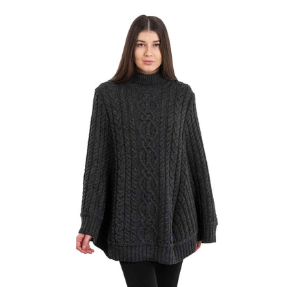 Woman wearing a charcoal colored Aran Cable Knit Poncho on a white background