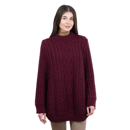 Woman wearing a wine colored Aran Cable Knit Ponchor on a white background