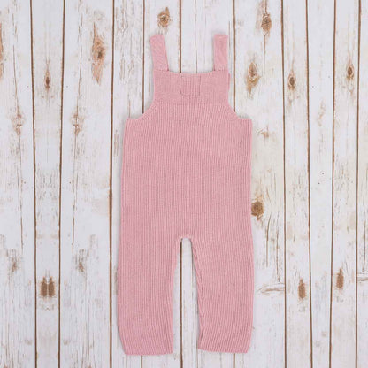 Reverse view of Pink Irish baby knitted romper, on a wooden background