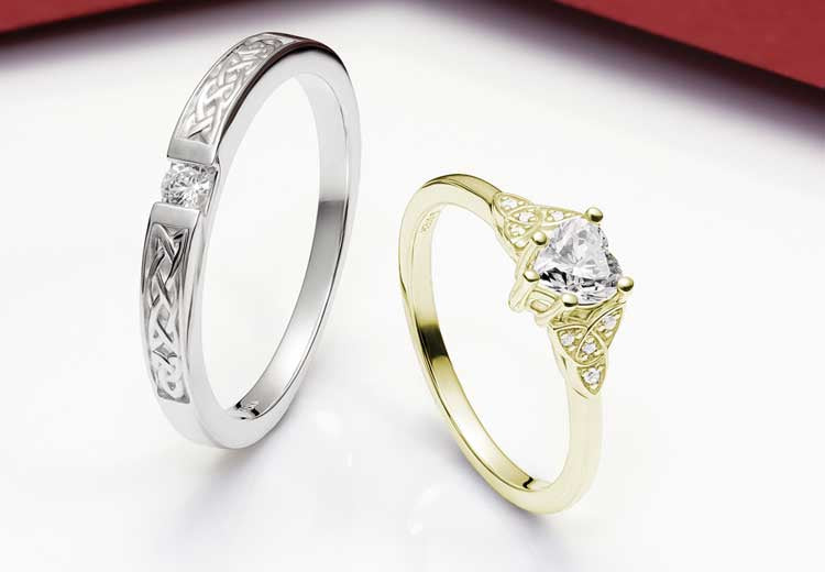 White and Yellow Gold Irish Engagement Rings with a Celtic Design on a white background