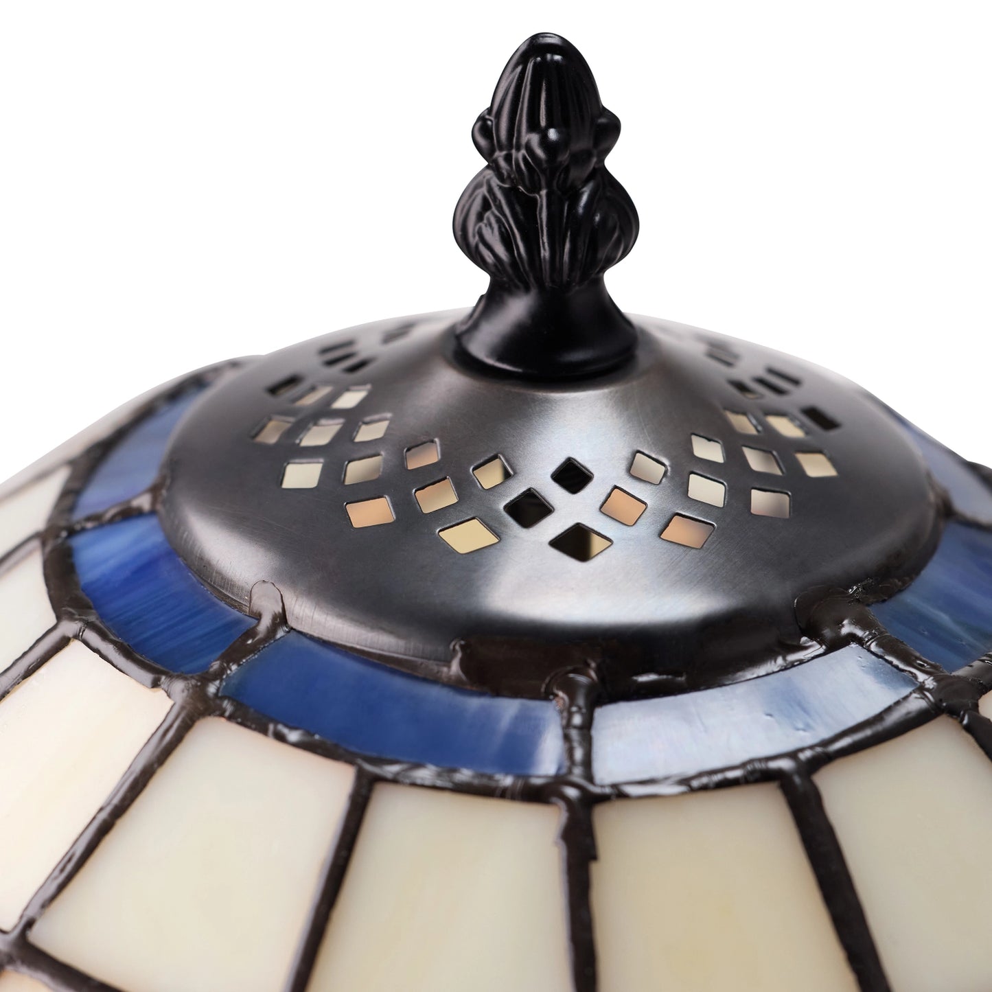 close-up of celtic blooming flower stained glass table lamp shade featuring cream-colored glass panels, blue glass accents, and a black top finial with diamond-shaped cutouts.