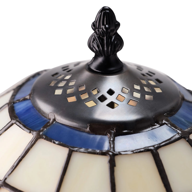 Close-up of Celtic Blooming Flower Stained Glass Table Lamp shade featuring cream-colored glass panels, blue glass accents, and a black top finial with diamond-shaped cutouts.