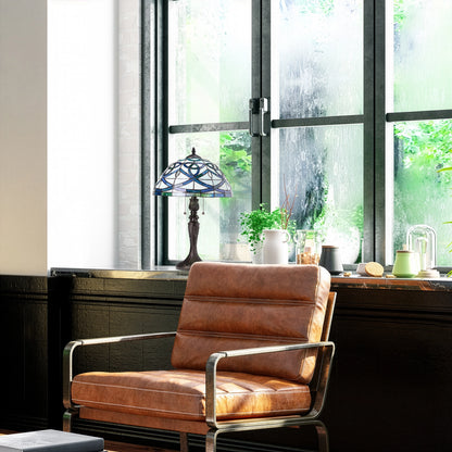 Celtic Stained Glass Dome Trinity Knot  Lamp Shade in front of a large window in an room with a brown leather armchair in a modern interior setting.