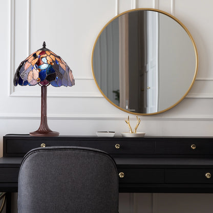 Celtic Stained Glass Fairy Pool Table Lamp on a black dresser with a round mirror above it.