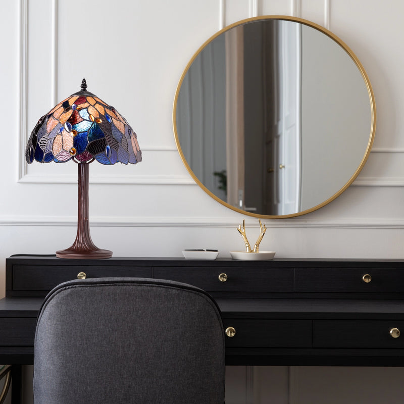 Celtic Stained Glass Fairy Pool Table Lamp on a black dresser with a round mirror above it.