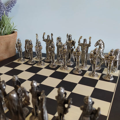 Irish Pewter Celtic Chess Set & Wooden Board with a plant in the background.