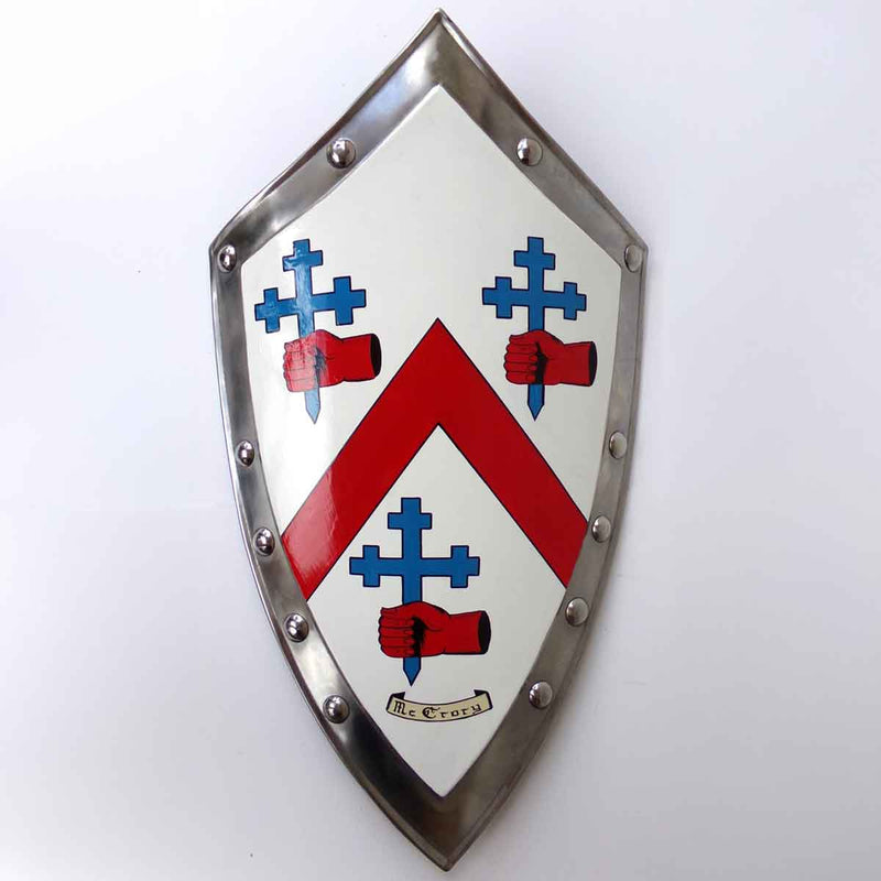 A Large Hand Painted Battle Shield with the coat of arms for 'McCrory' mounted on a white wall
