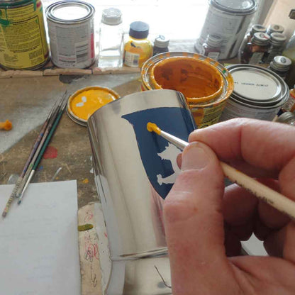 Close up of our artist hand painting a Coat of Arms tankard