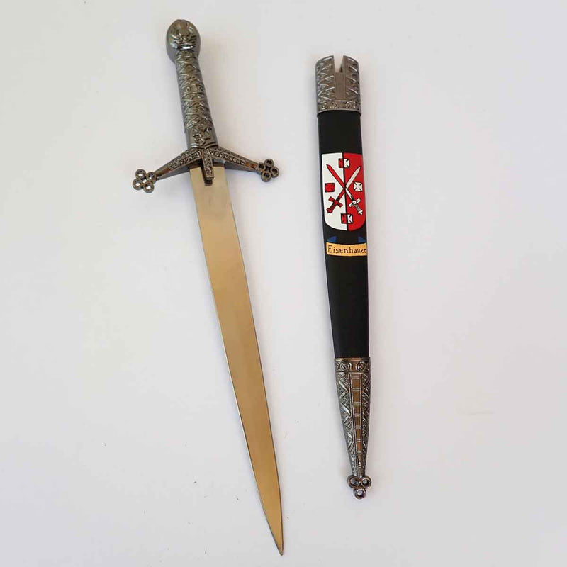 Claymore Dagger with ornate hilt beside a sheath decorated with a Hand Painted Coat of Arms on a white surface
