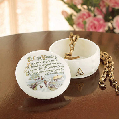 Belleek Irish Blessing Gift Box, with open lid featuring an Irish blessing text, on a wooden surface with flowers in the background