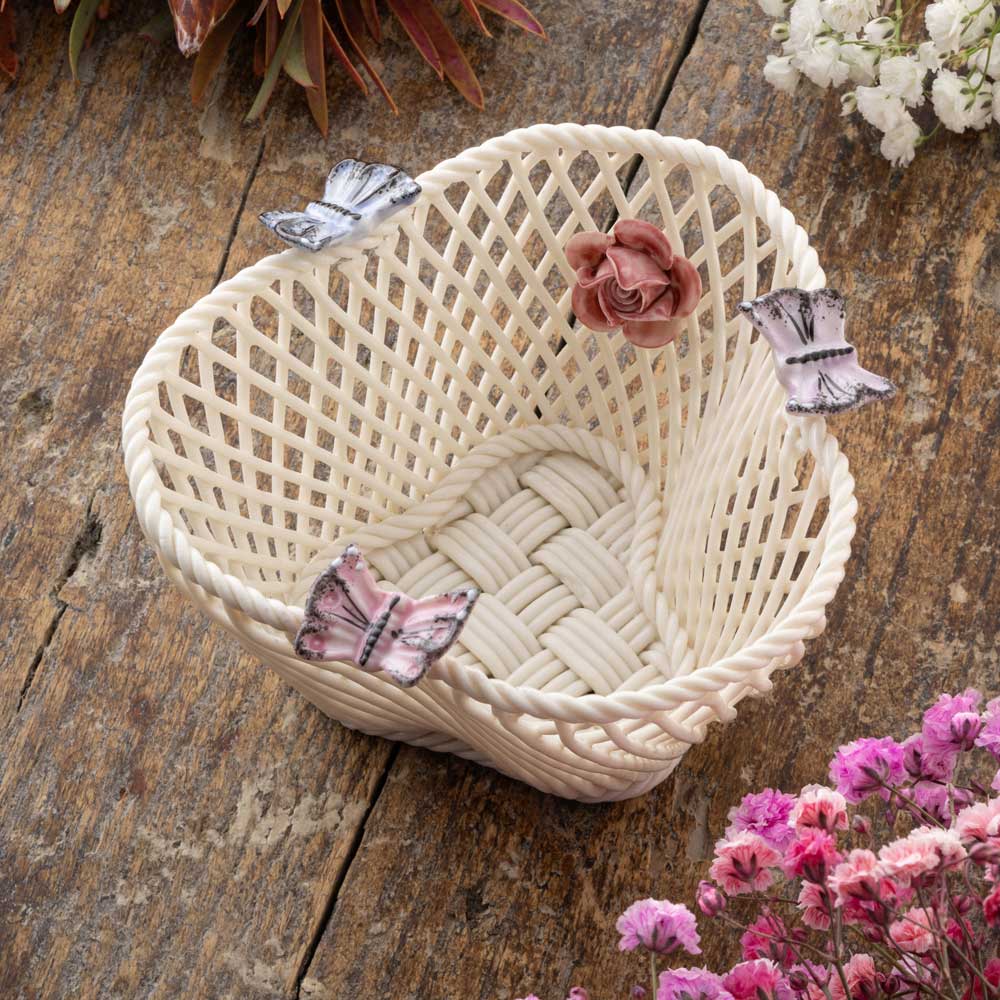 belleek pottery butterfly irish basket decorated with hand painted butterflies and flowers on a wooden surface
