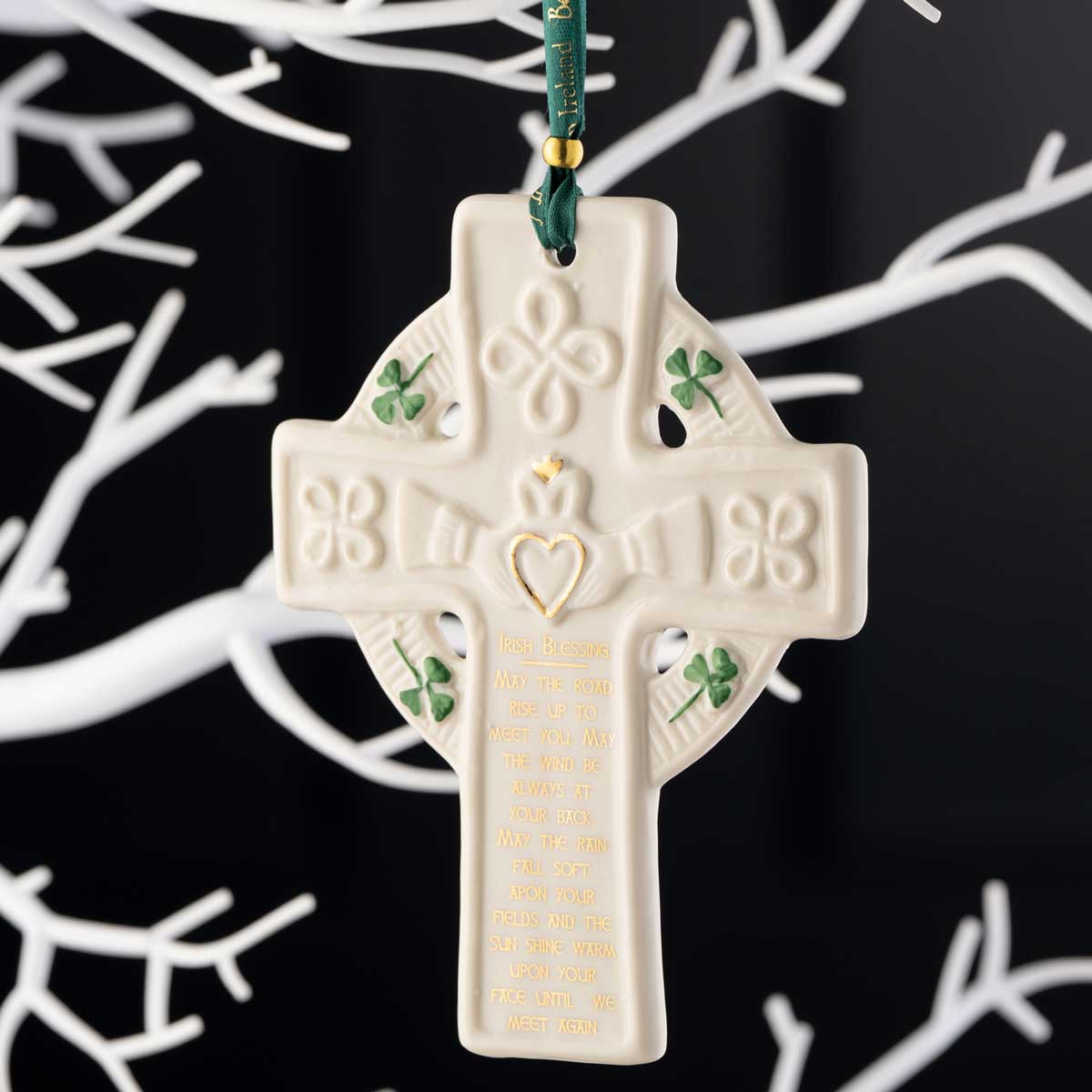 belleek pottery claddagh blessing cross ornament hanging from a green ribbon on a white tree against a black background