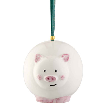 Irish Christmas | Belleek Pottery Pig Hanging Ornament suspended by a dark green ribbon with a gold connector on a white background.