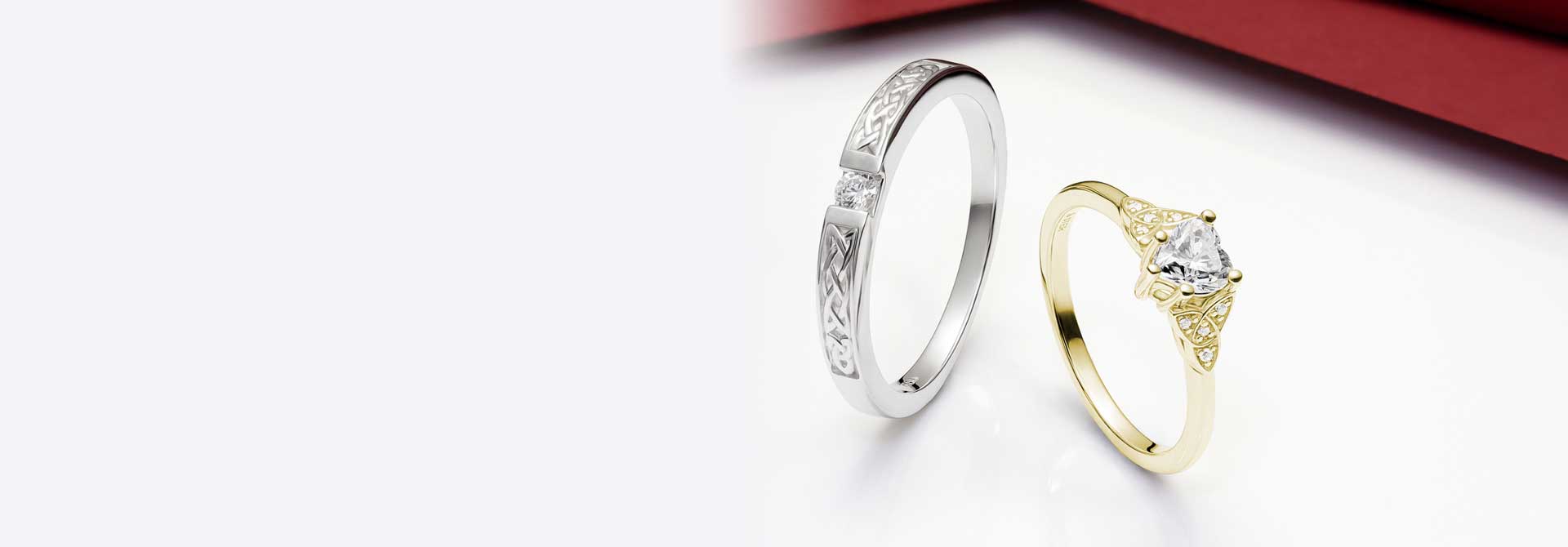 White and Yellow Gold Irish Engagement Rings with a Celtic Design on a white background