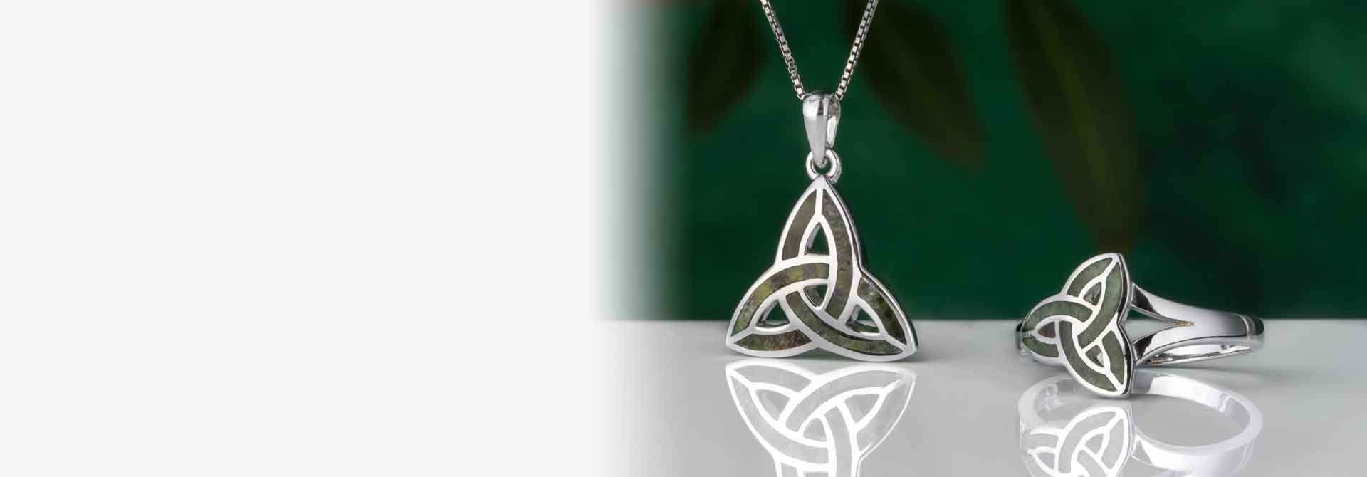 Sterling Silver Celtic Trinity Knot Necklace & Ring set with Connemara Marble on a reflective surface with a green background