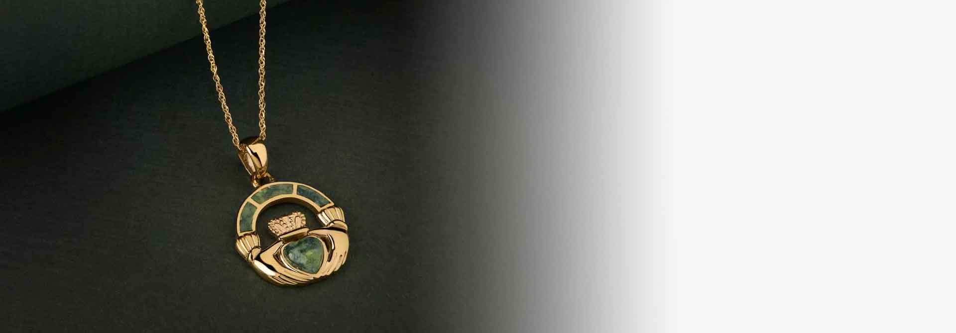 Gold necklace with a green connemara marble heart on a dark background