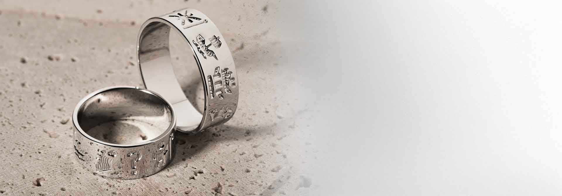 Two silver History of Ireland rings on a textured surface