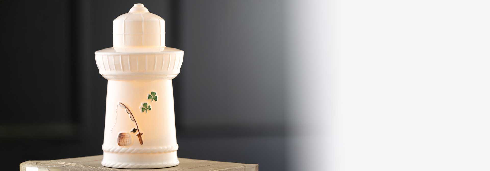 Belleek Pottery Edition Piece 2026 LED Irish Lighthouse with a shamrock and fishing rod detail on a dark background