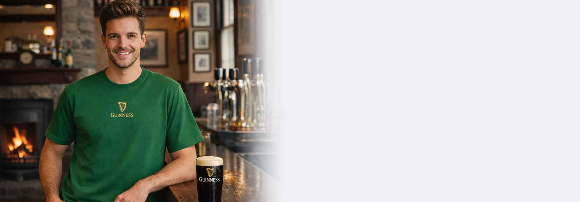 Man wearing a Guinness® Are You Toucan To Me Green t-shirt sitting at a bar with a pint of Guinness.