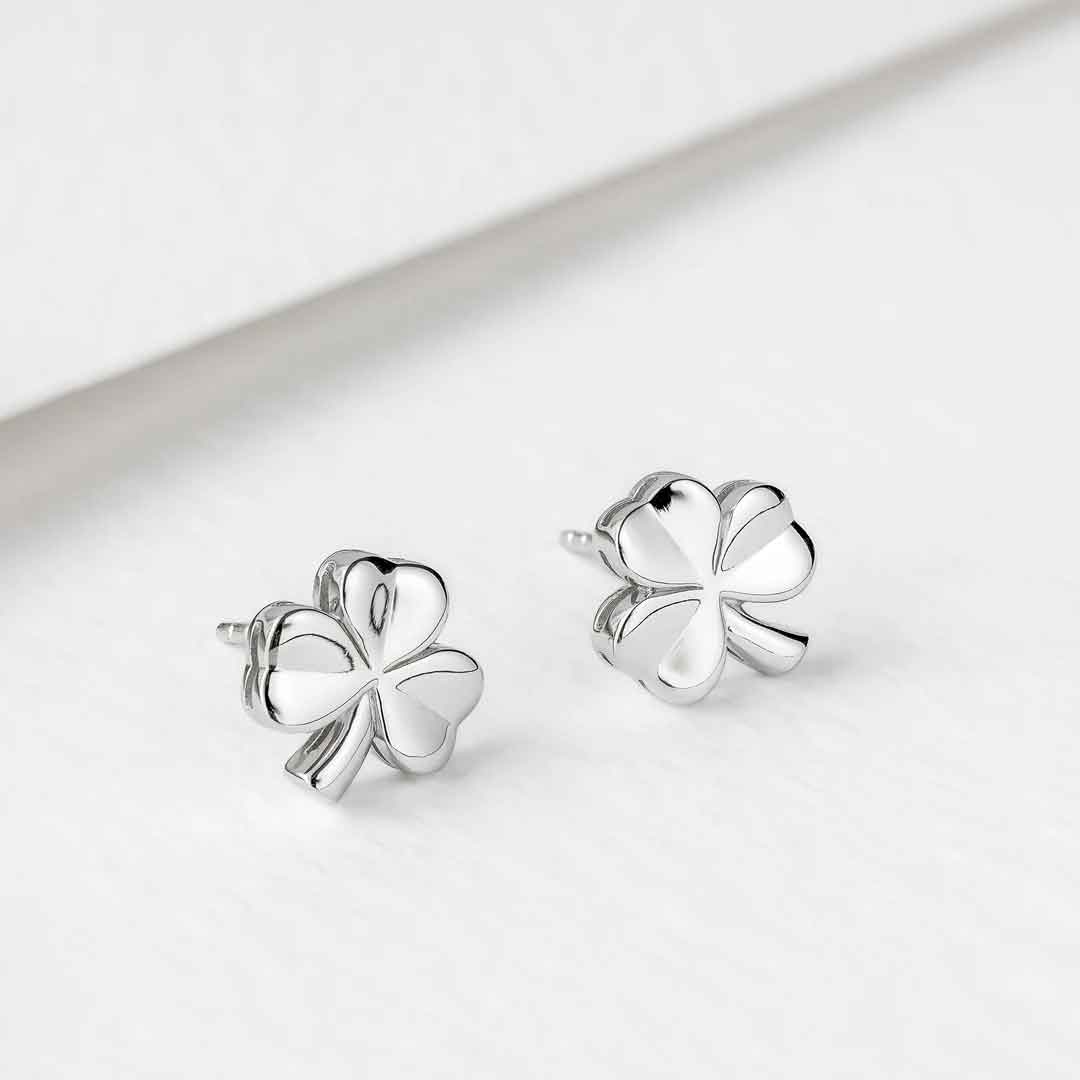 sterling silver shiny stud shamrock earrings on a light gray background
