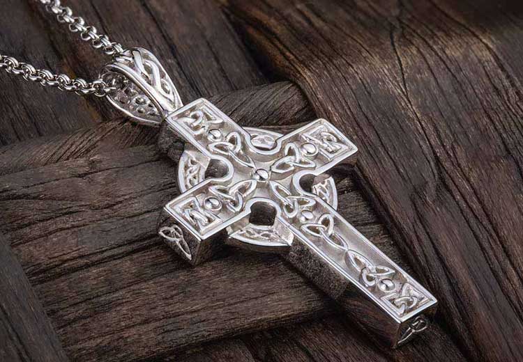 Sterling Silver Celtic Trinity Knot detail Cross with Chain on a wooden surface
