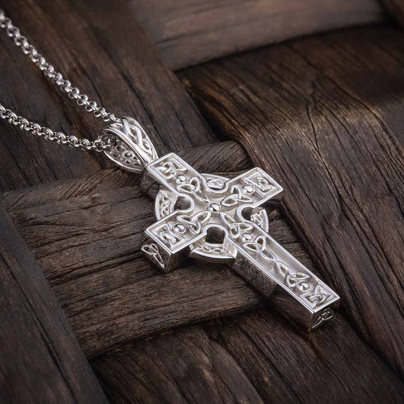 Men's Sterling Silver Celtic Trinity Knot detail Cross with Chain on a wooden surface