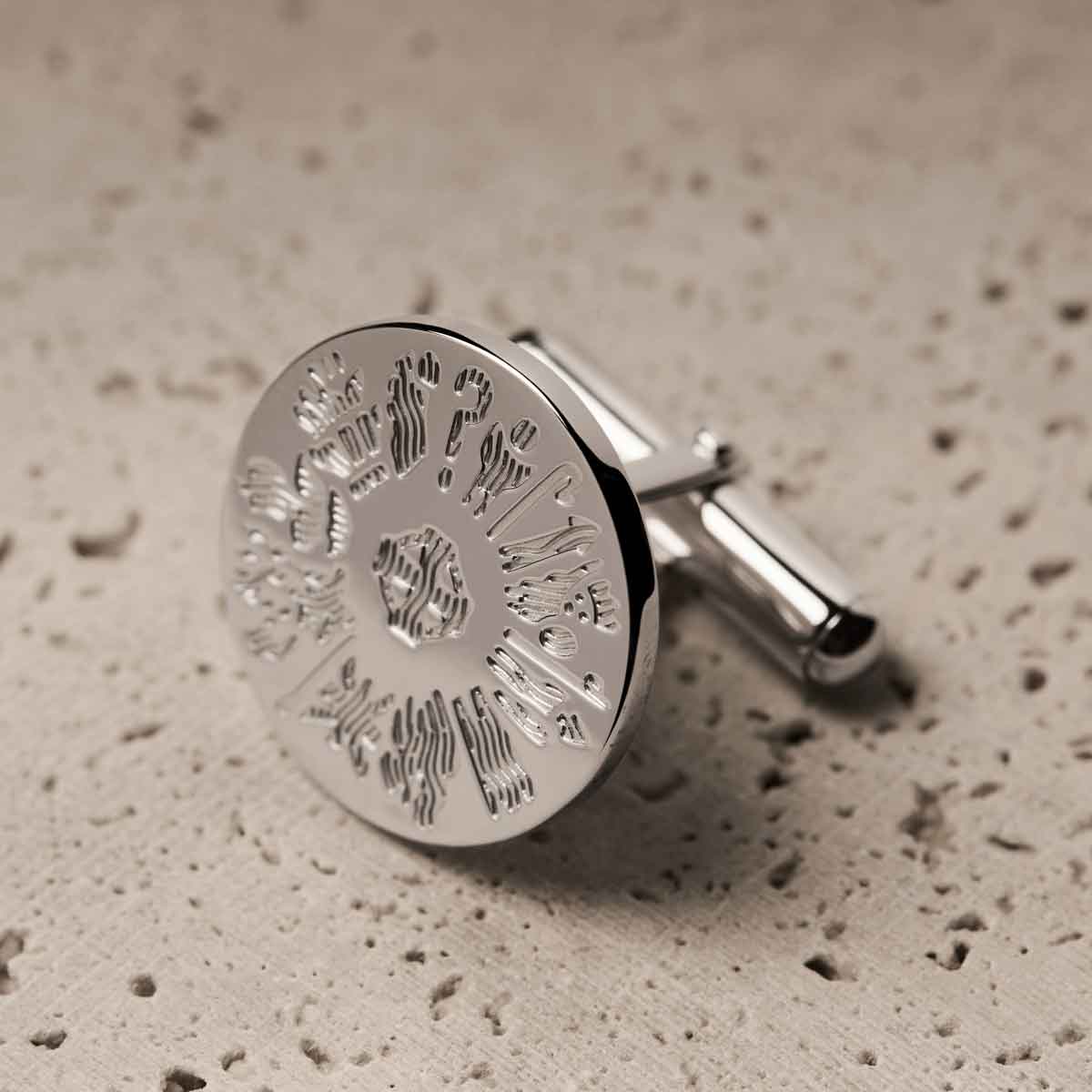 sterling silver history of ireland round cufflink on a textured beige surface