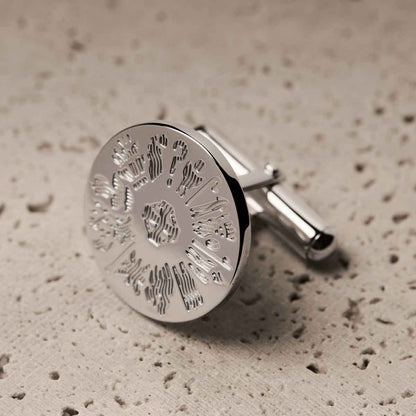 Sterling Silver History of Ireland Round Cufflink on a textured beige surface