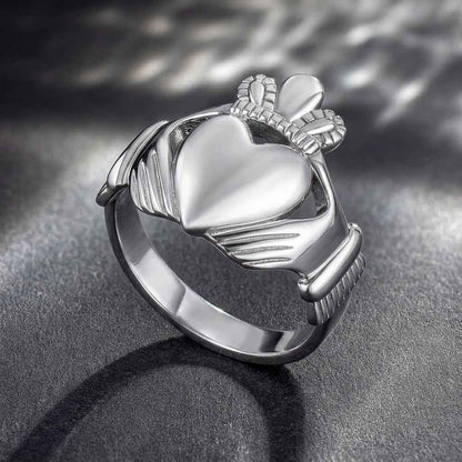 Sterling Silver Large Heart Men's Claddagh Ring on a dark textured surface