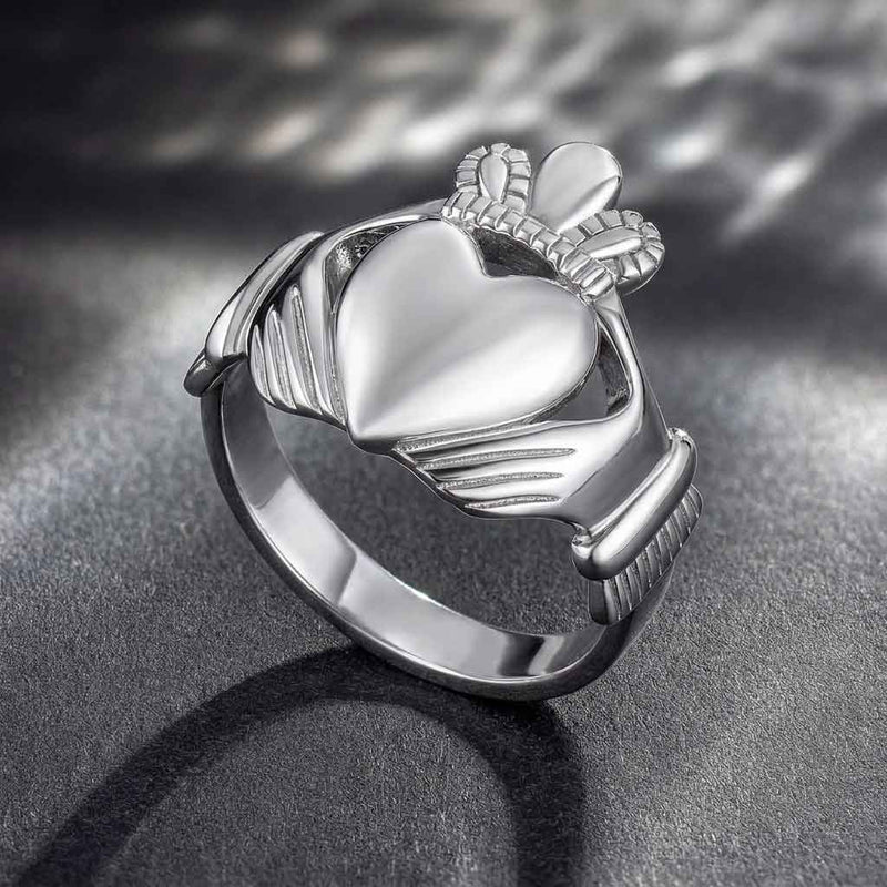 Sterling Silver Large Heart Men's Claddagh Ring on a dark textured surface
