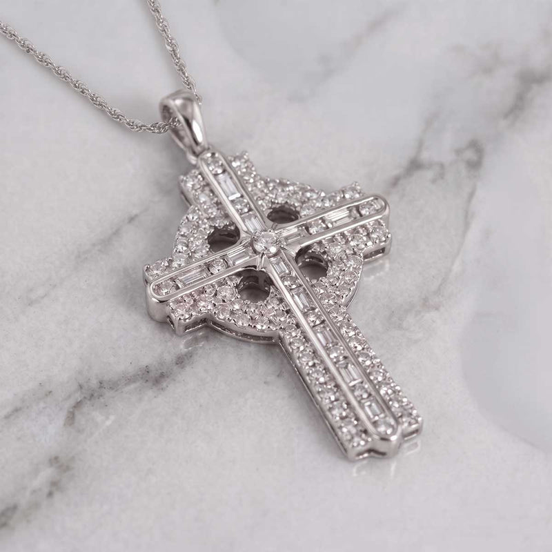 14k White Gold Diamond Celtic Cross Pendant, resting on a light gray and white marble surface, resting on a white and gray marble surface.